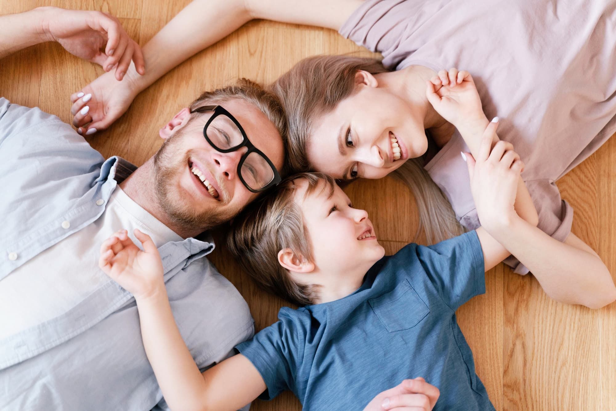 View from above of family smiling and hugging on the floor